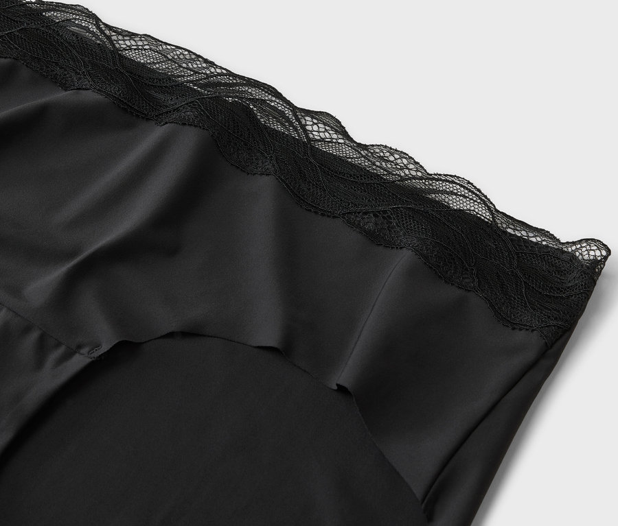 Detailný záber na čierny hodvábny top s čipkovanými detailmi.