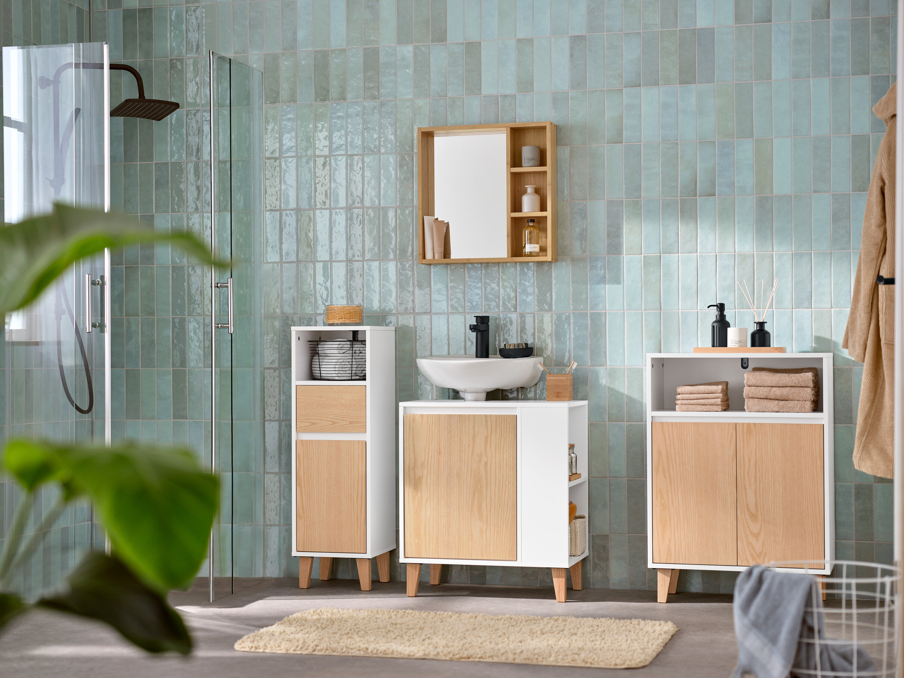 Kúpeľňa s umývadlovou skrinkou s dvierkami a poličkou naboku, zrkadlom s odkladacími poličkami, odkladacou skrinkou s 2 dvierkami a otvoreným priečinkom a kúpeľňovou skrinkou so zásuvkou a dvierkami, úzka.