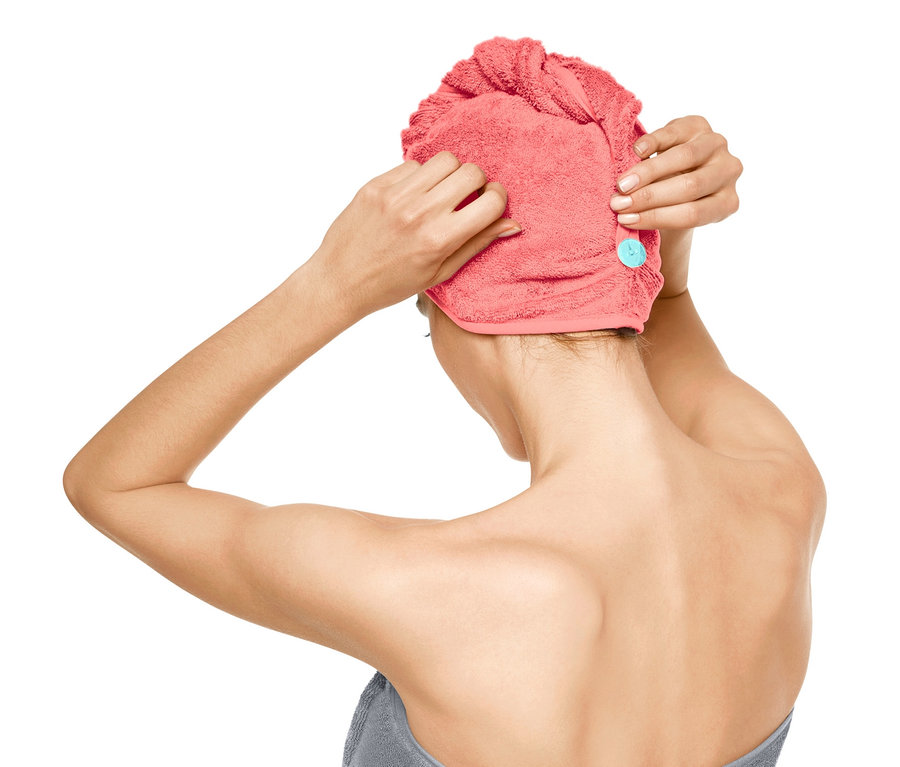 Žena si nasadzuje uterákový turban.
