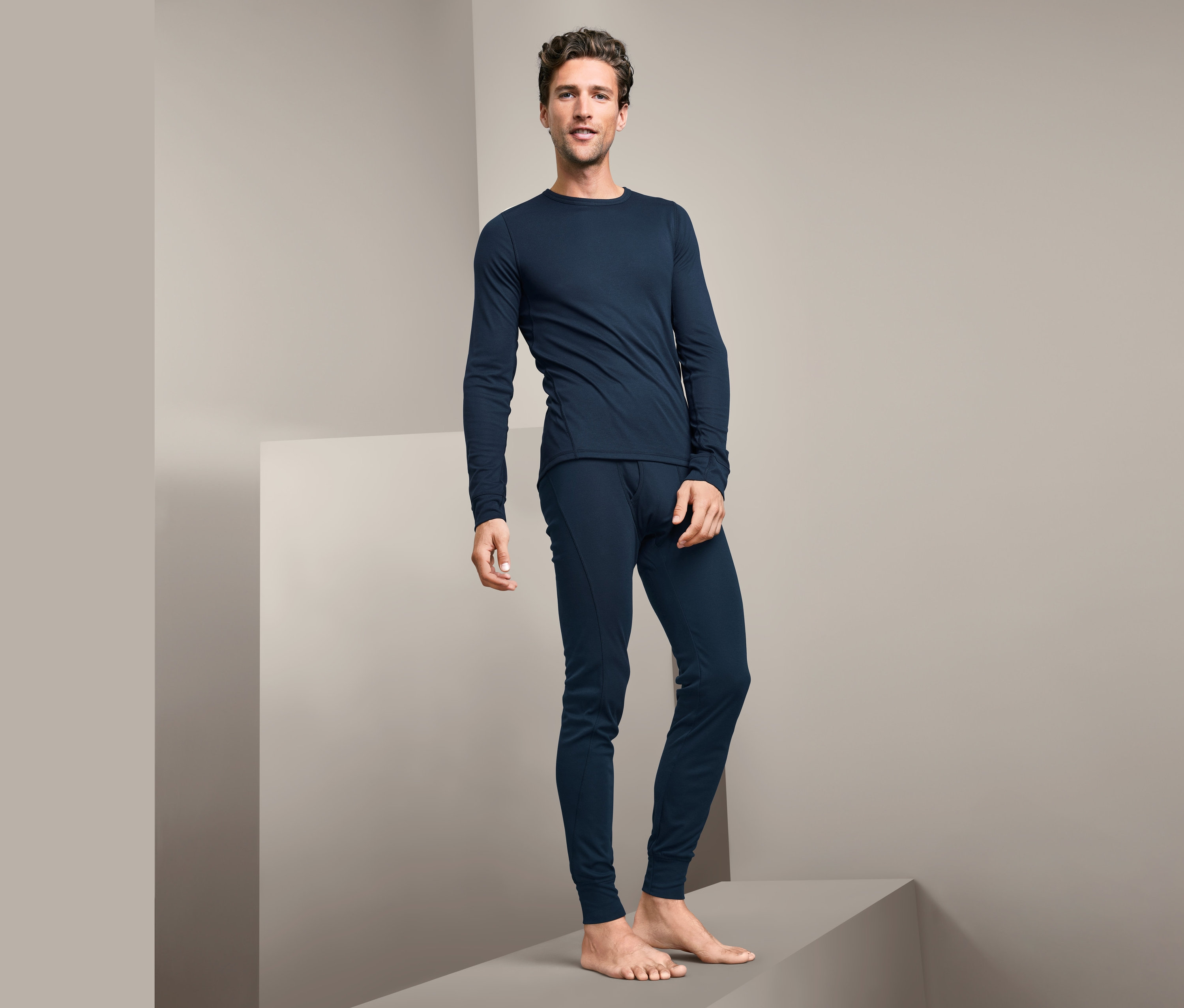 Muž stojí na podstavci a má na sebe funkčnú termobielizeň.