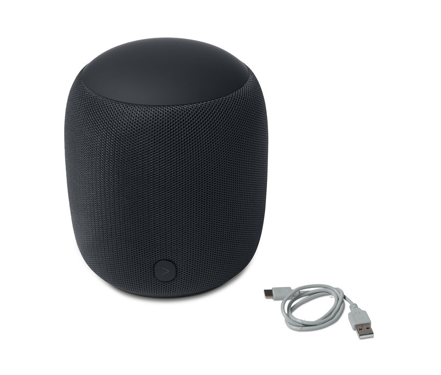Antracitový dizajnový reproduktor s Bluetooth® L a sivý nabíjací kábel ležia na bielom pozadí.