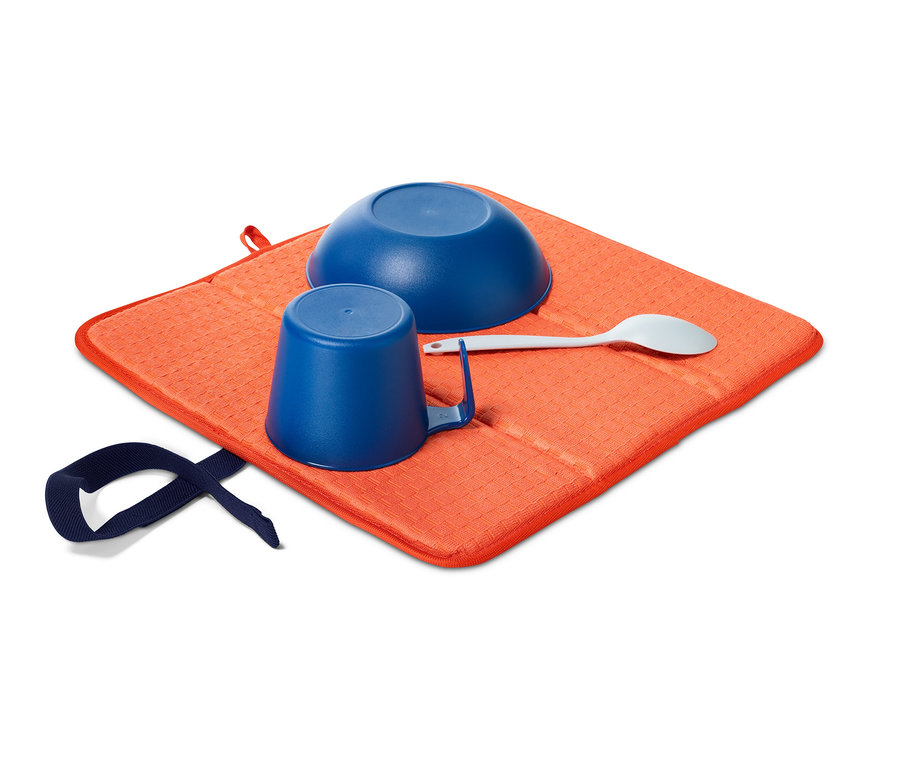 Modrá miska, hrnček a lyžica na oranžovej skladacej odkvapkávacej podložke.