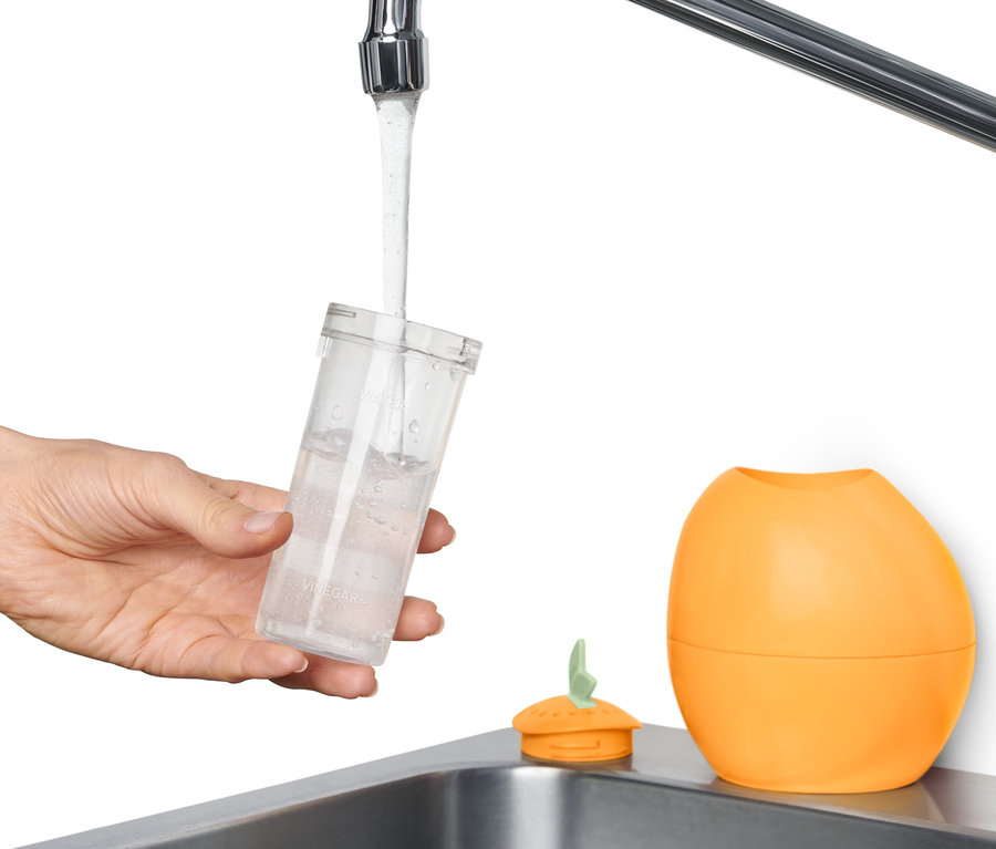 Ruka plní vodou čistič mikrovlnnej rúry.