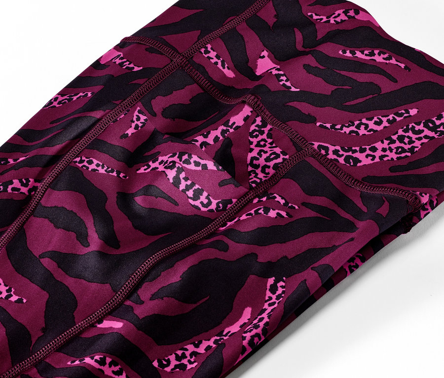 Detail trojštvrťových športových legín s celoplošnou potlačou.