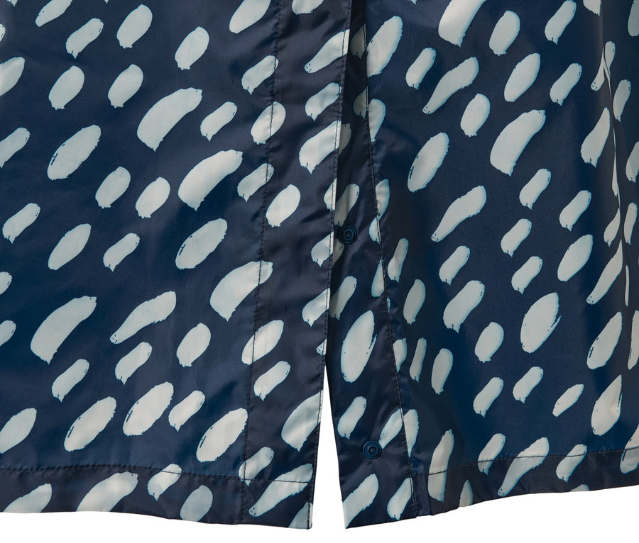 Detail modrého ponča do dažďa s rukávmi a svetlým vzorom.