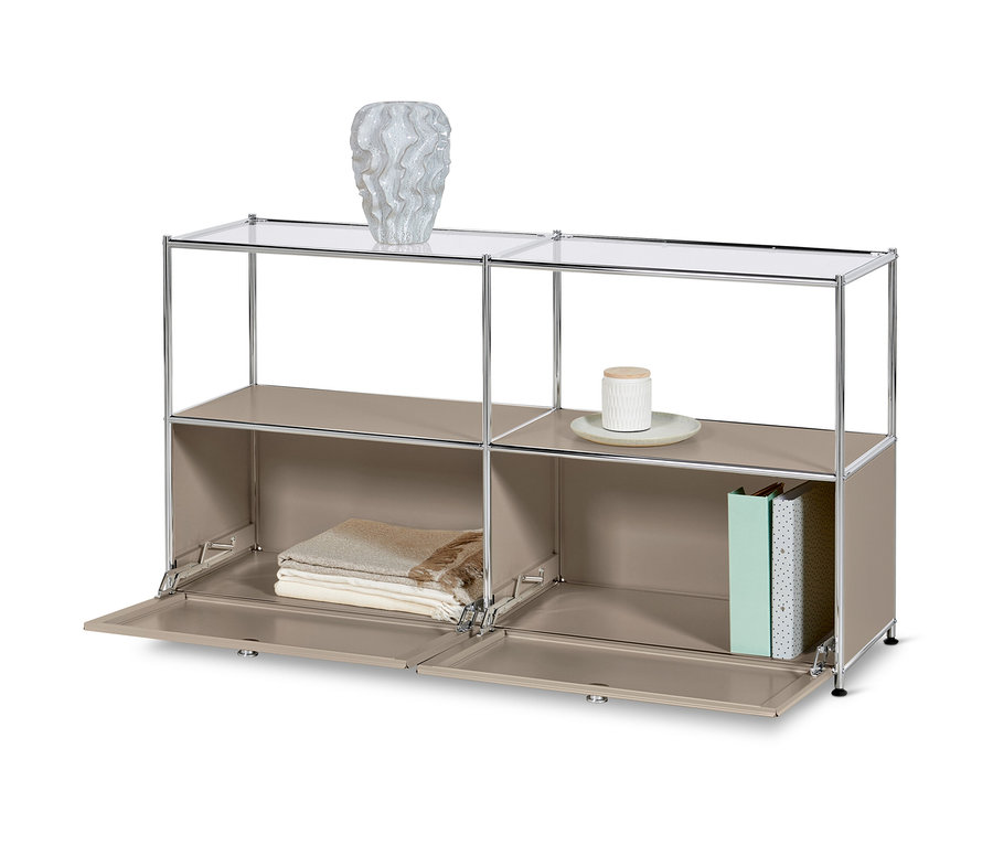 Tmavosivá kovová odkladacia skrinka »CN3« s 2 výklopnými dvierkami a sklenými poličkami. Na hornej poličke váza, na spodných poličkách deky a knihy.