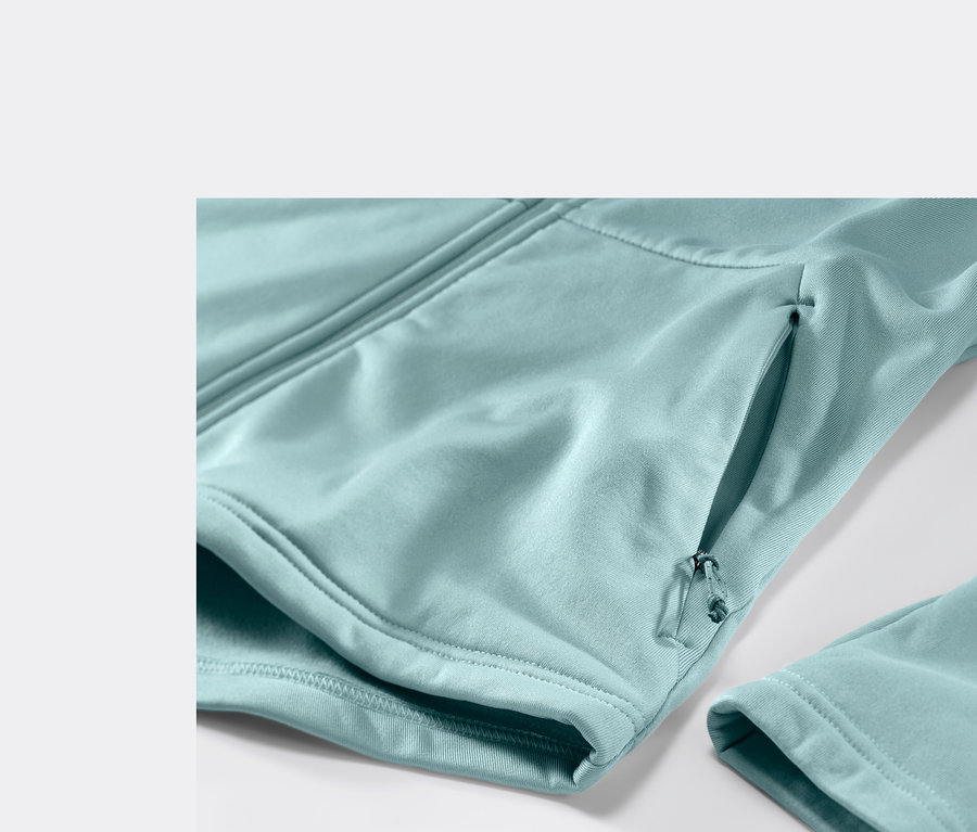 Detail svetlomodrej termobundy s vreckom na zips a rukávom.