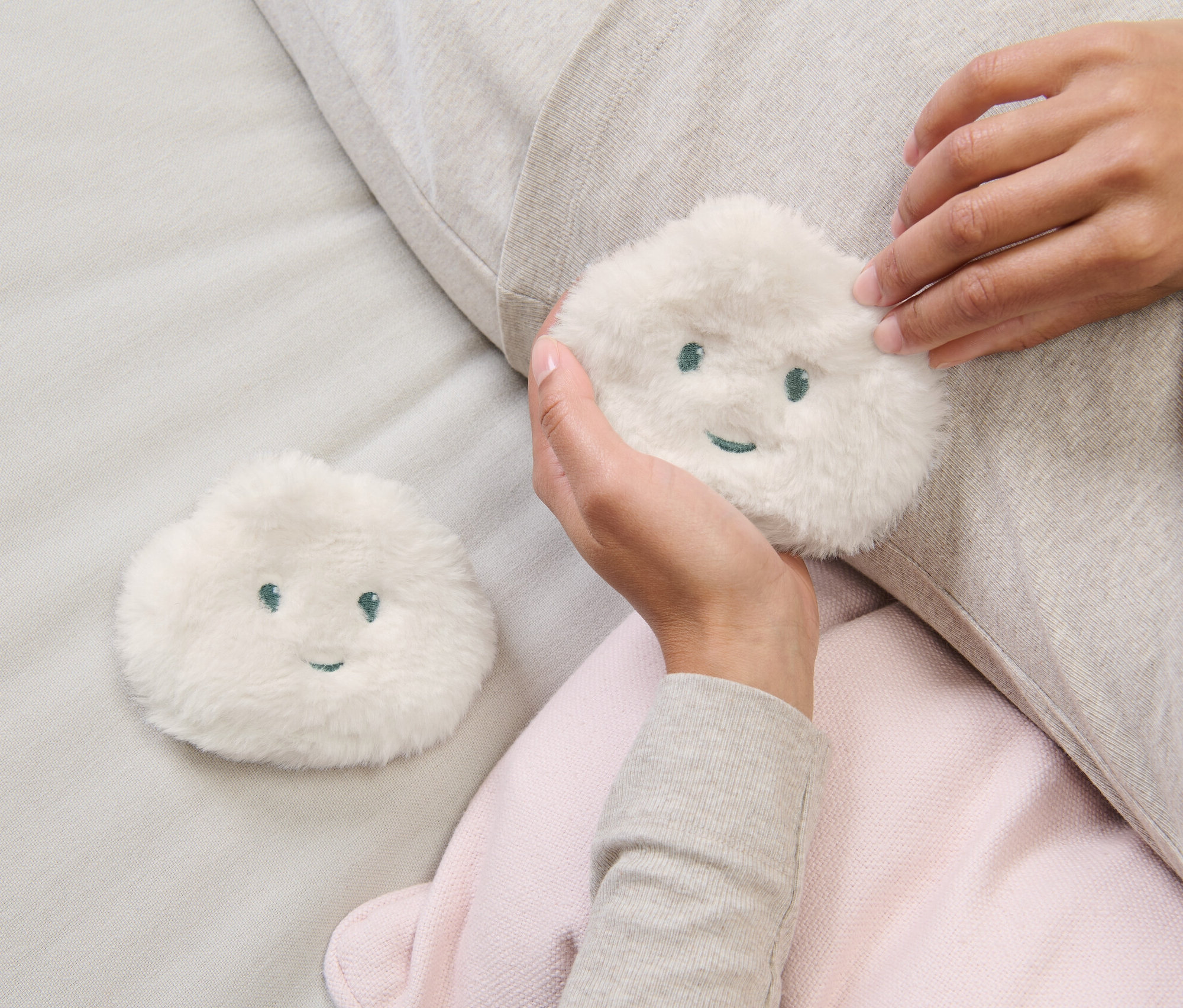 Žena drží v ruke jeden z dvoch hrejivých vankúšikov do vrecka.