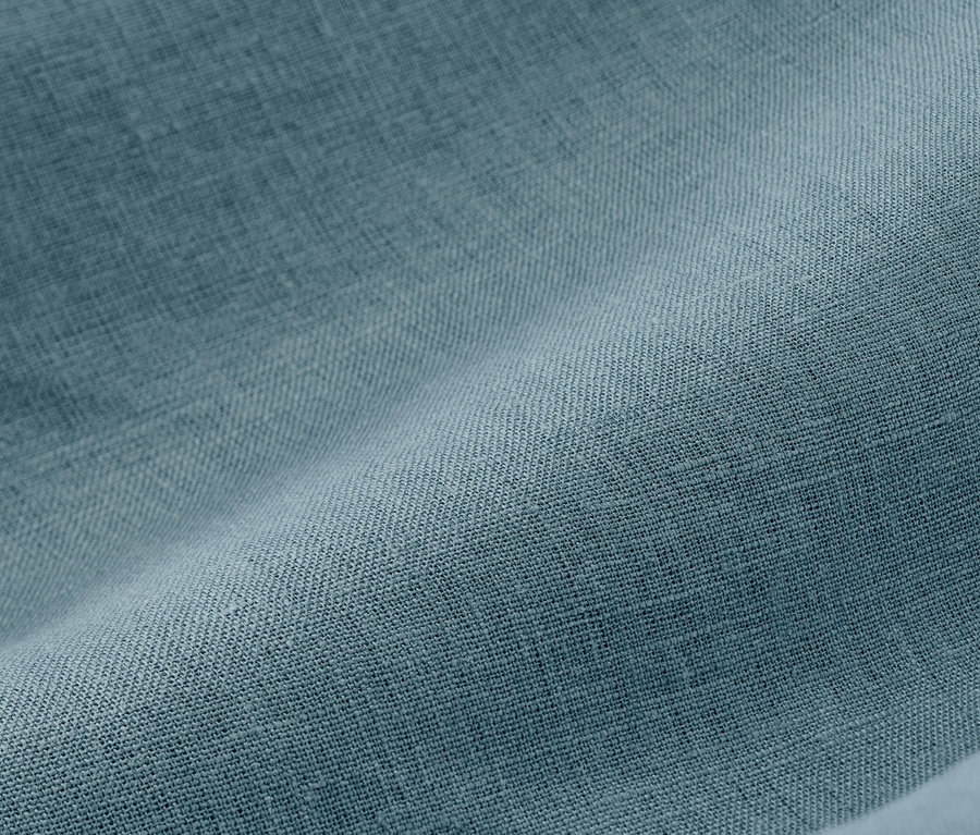 Detail modrej ľanovej posteľnej bielizne.