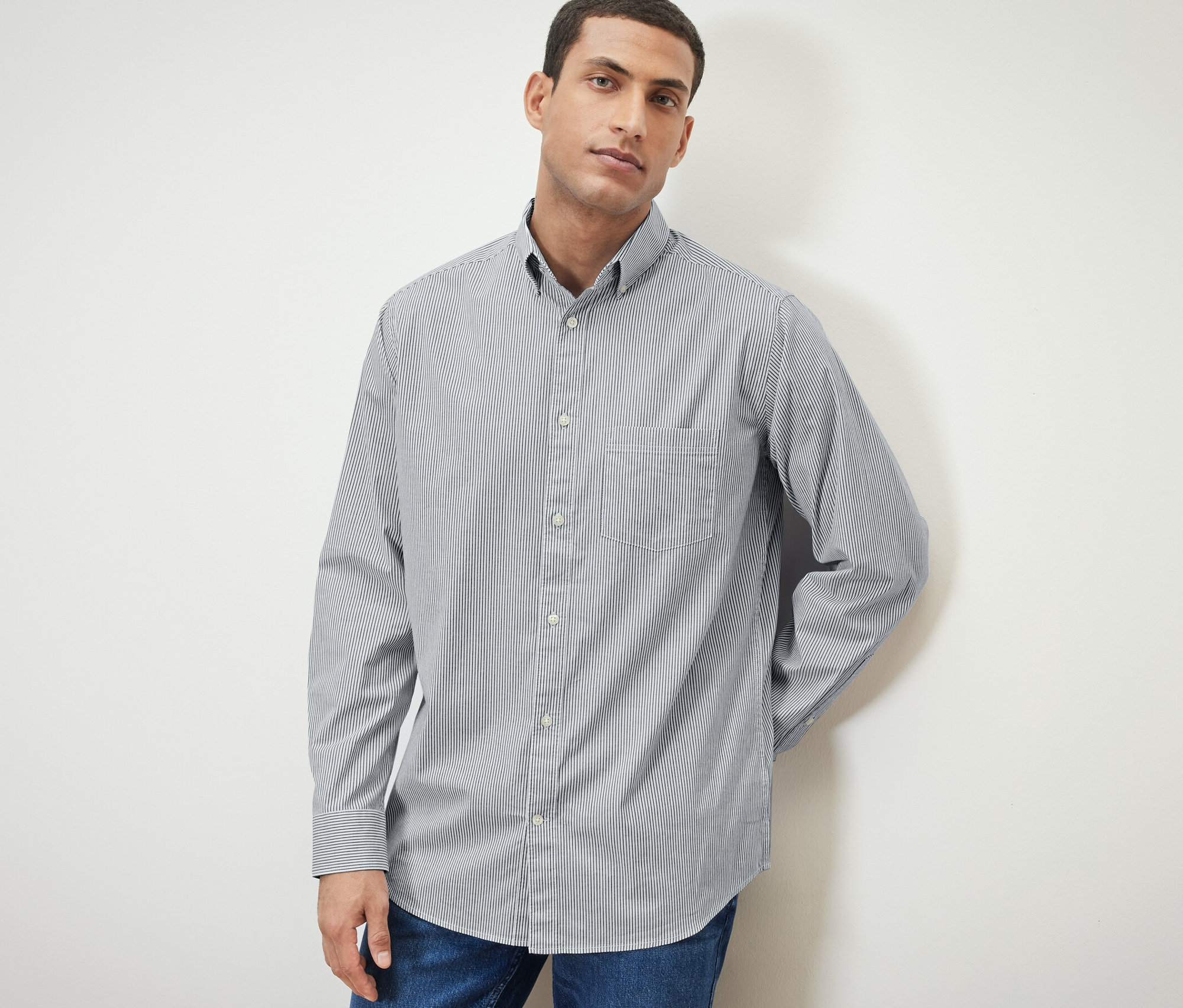 Muž pózuje v košeli.