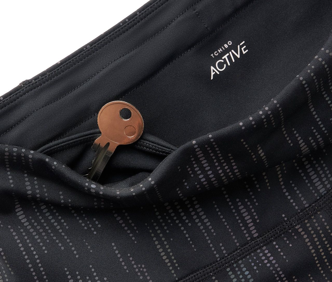 Detail čiernych legín Tchibo Active s kľúčom vo vrecku.