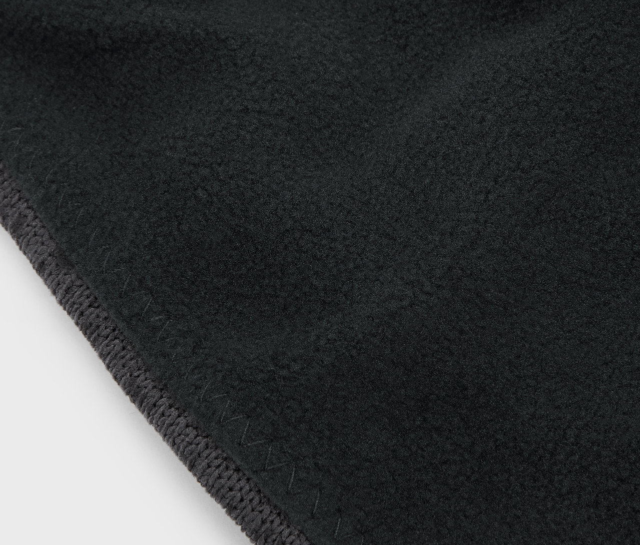 Detailný záber na čiernu látku so sivým lemom.