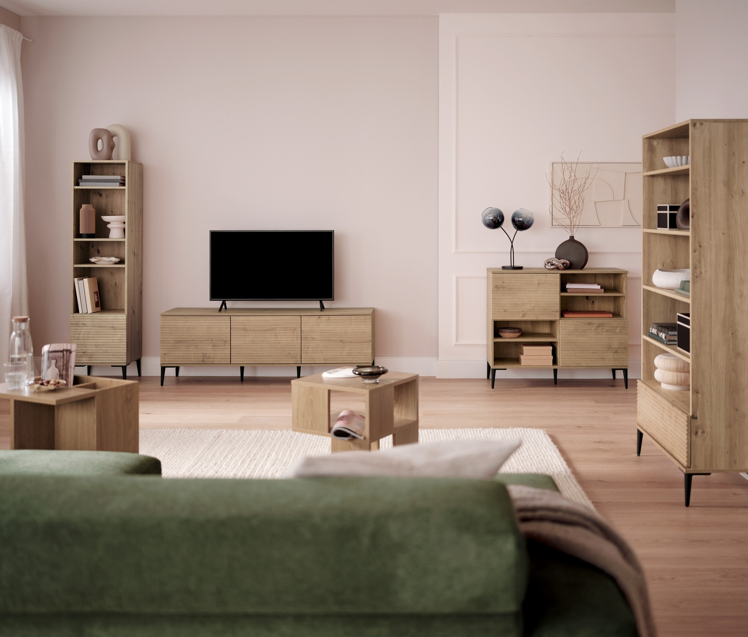 Obývacia izba s televízorom, knižnicami a konferenčnými stolíkmi.