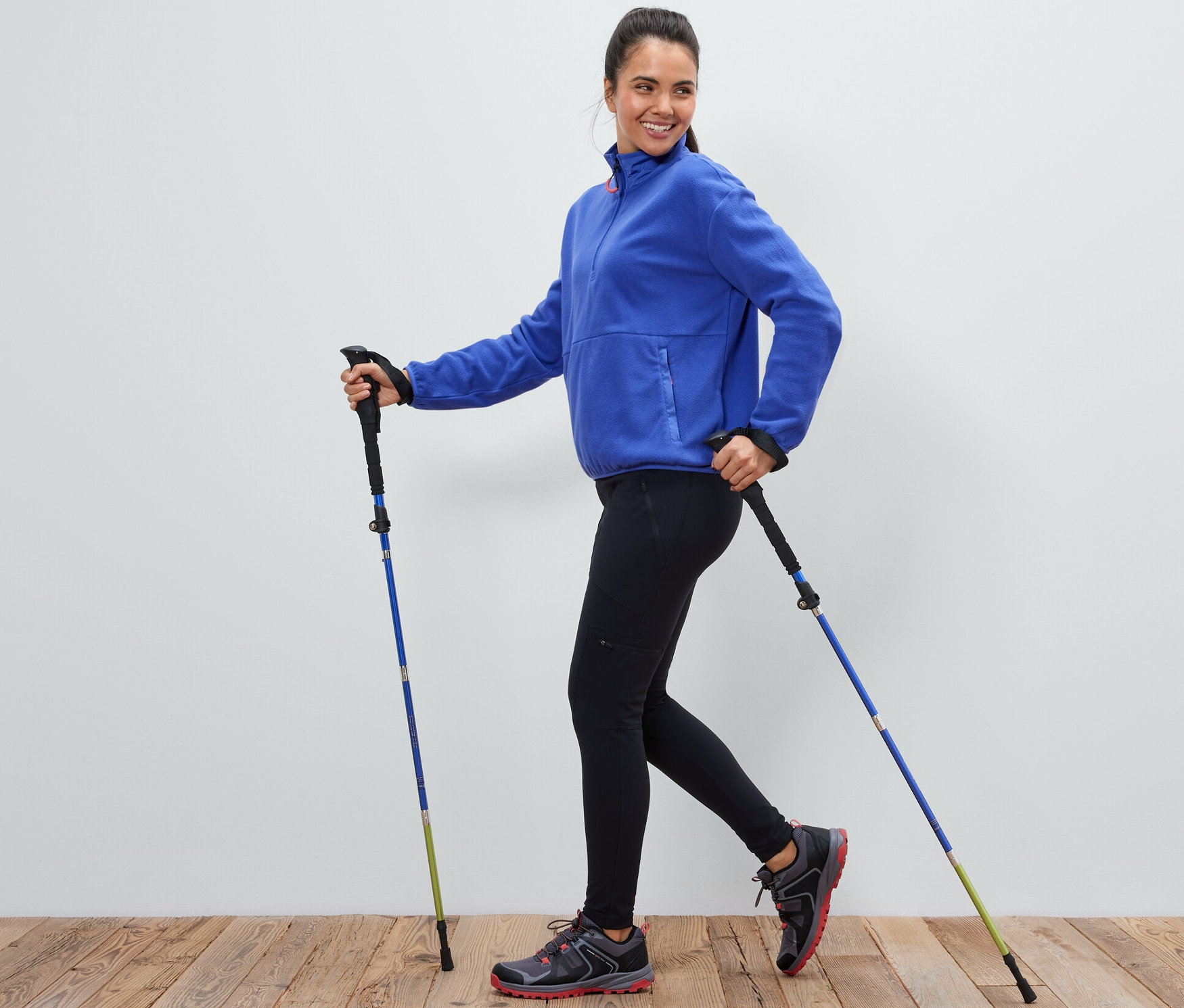 Žena používa pár skladacích trekingových palíc.