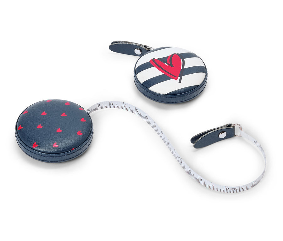 Dva modré zvinovacie metre ležia na bielom, jeden s červenými srdiečkami, druhý s prúžkami a červeným srdcom.