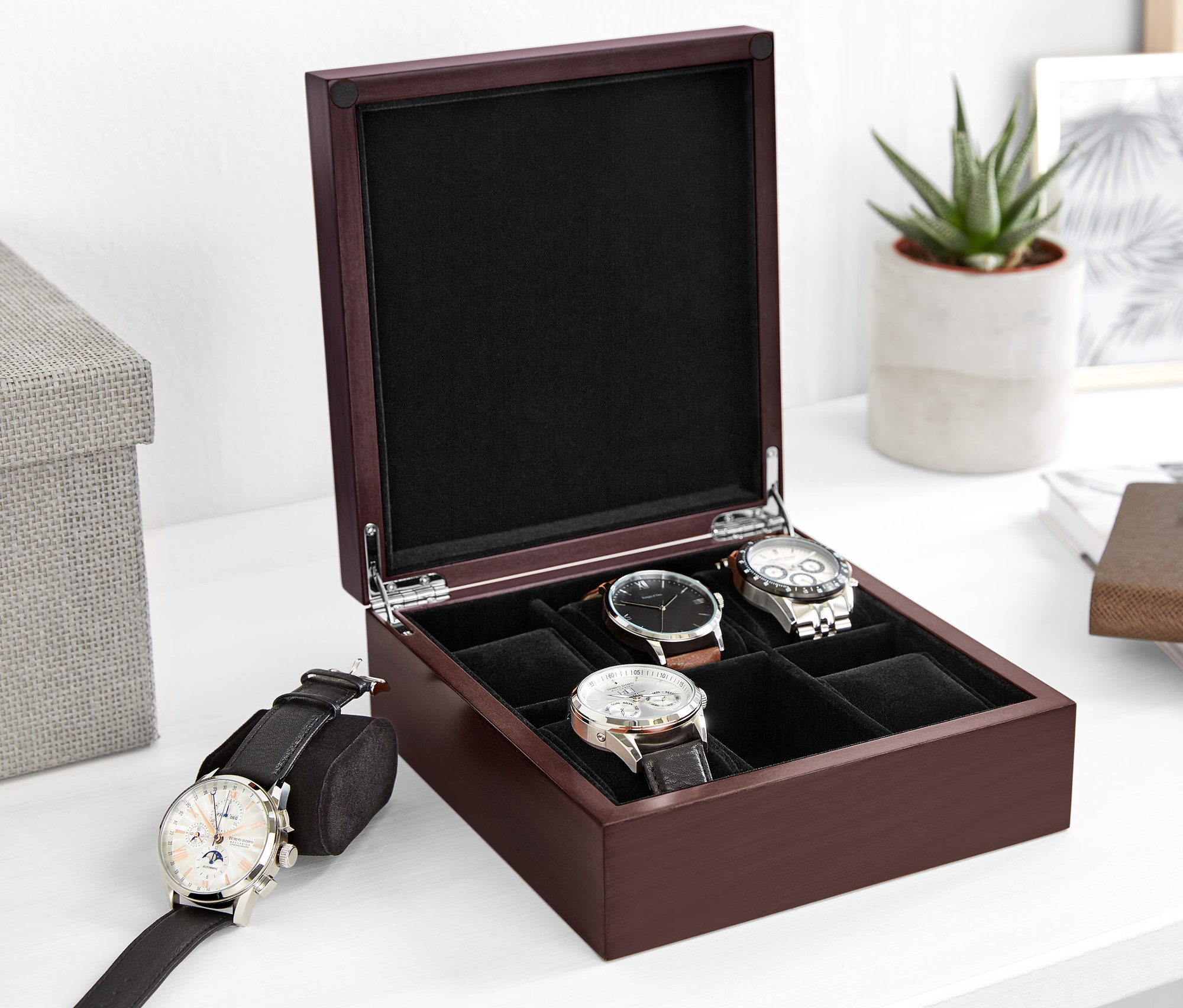 Otvorená drevená škatuľka na hodinky s niekoľkými hodinkami vnútri.