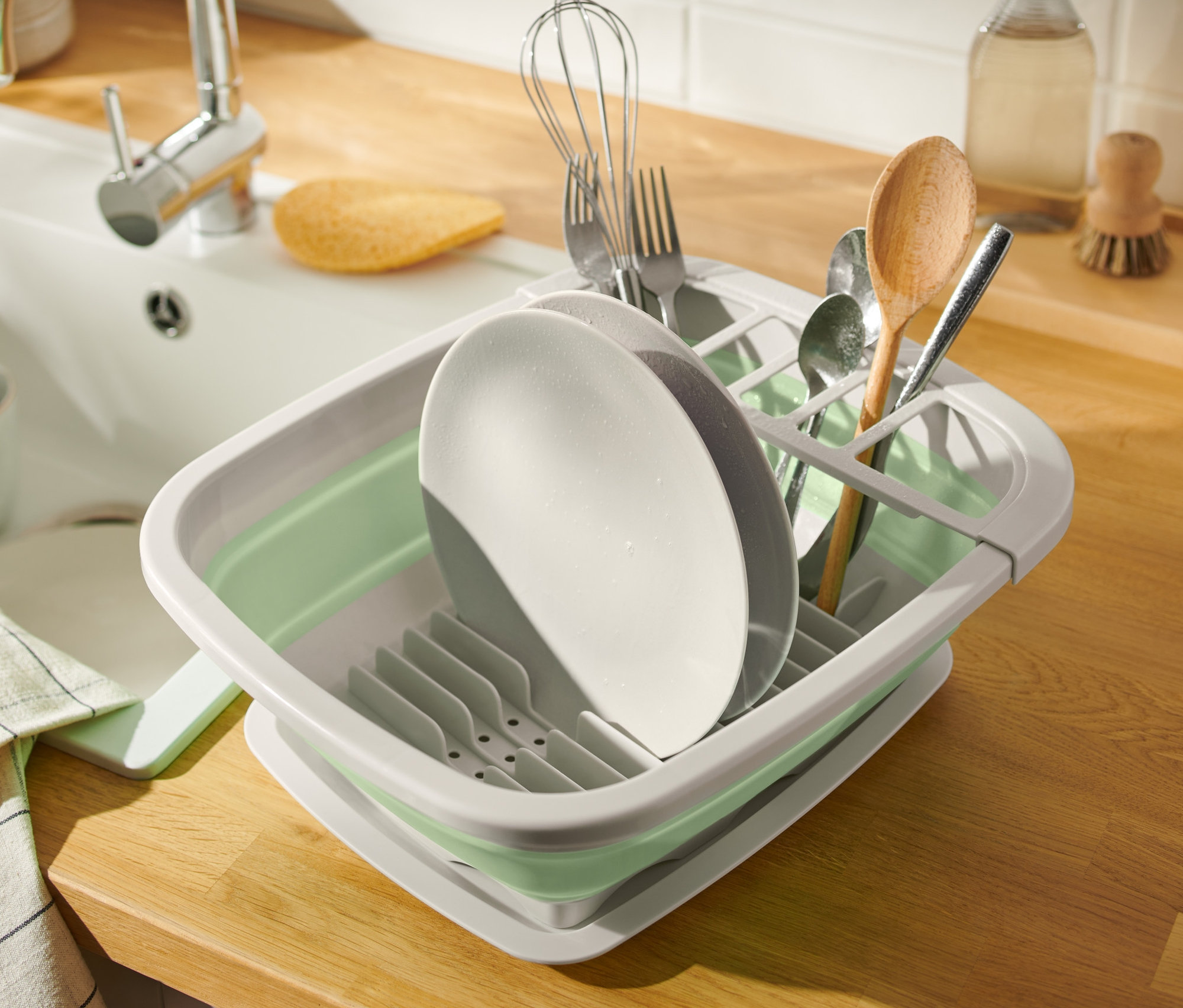 Riad v skladacom odkvapkávači na riad vedľa drezu.