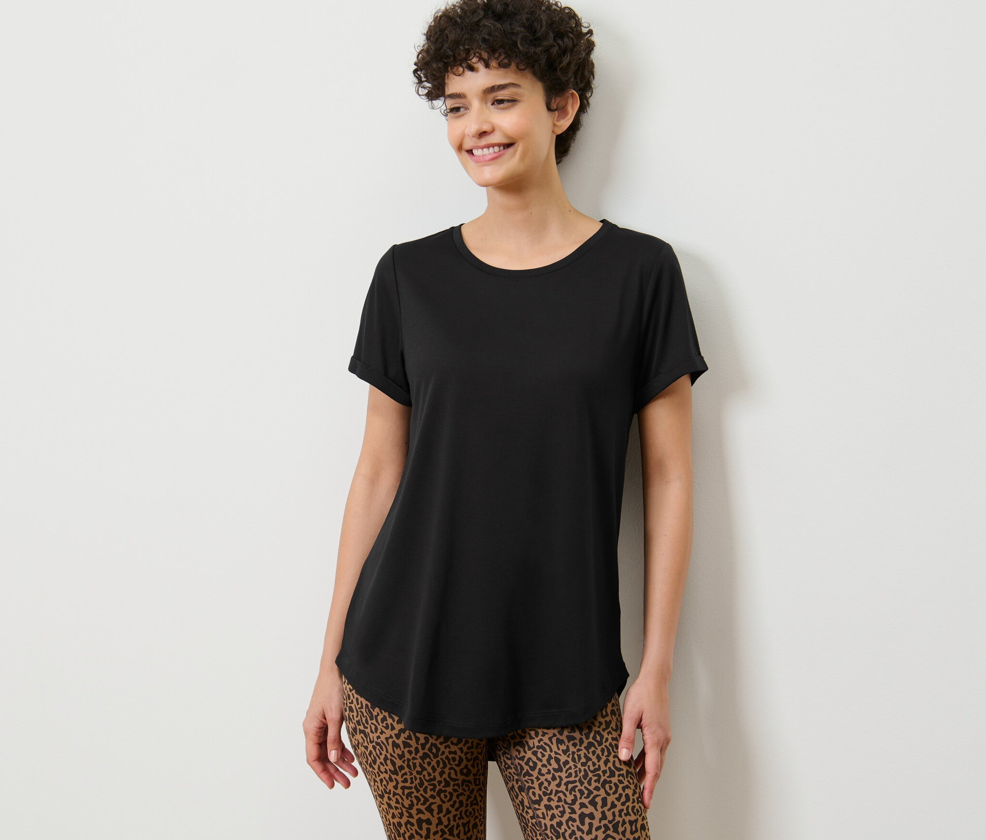 Žena pózuje v čiernom dlhom tričku.