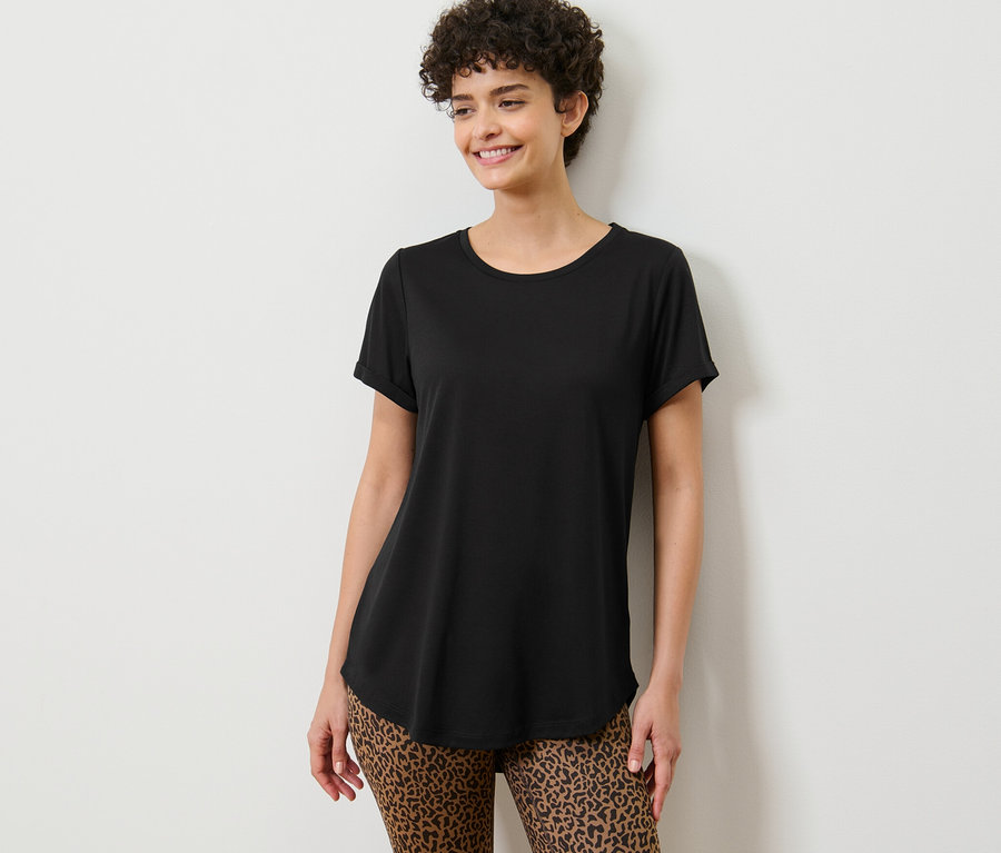 Žena pózuje v čiernom dlhom tričku.