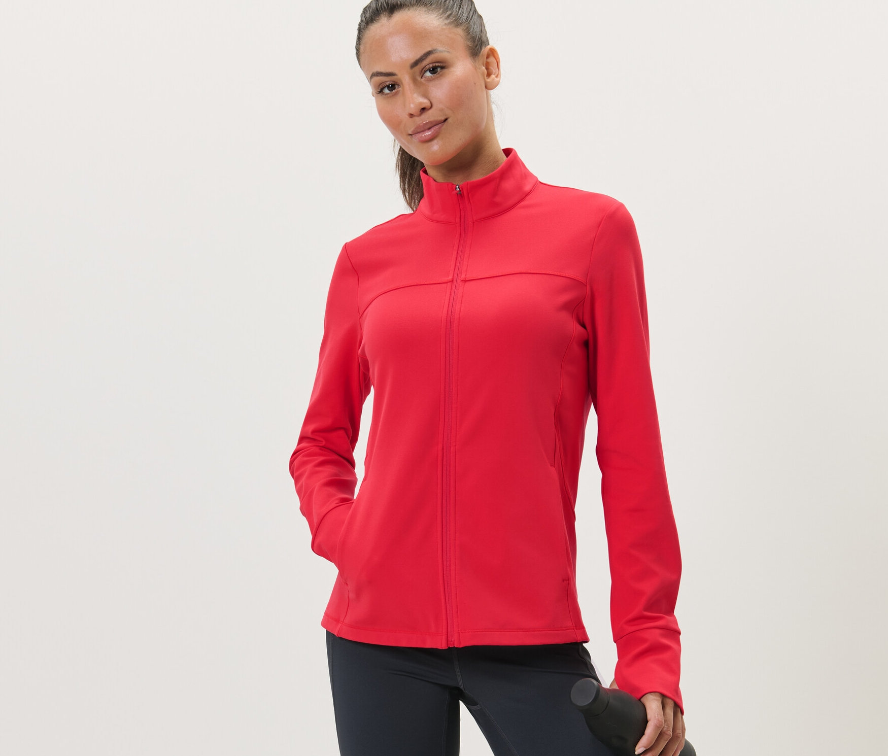 Žena má na sebe červenú športovú bundu.