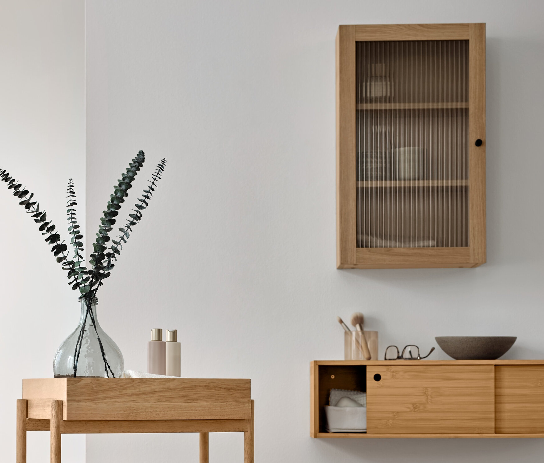 Zariadenie kúpeľne s dreveným stojanovým regálom s 3 priehradkami, vstavanou skriňou s dverami z ryhovaného skla a stojanom na uteráky z masívneho dreva.