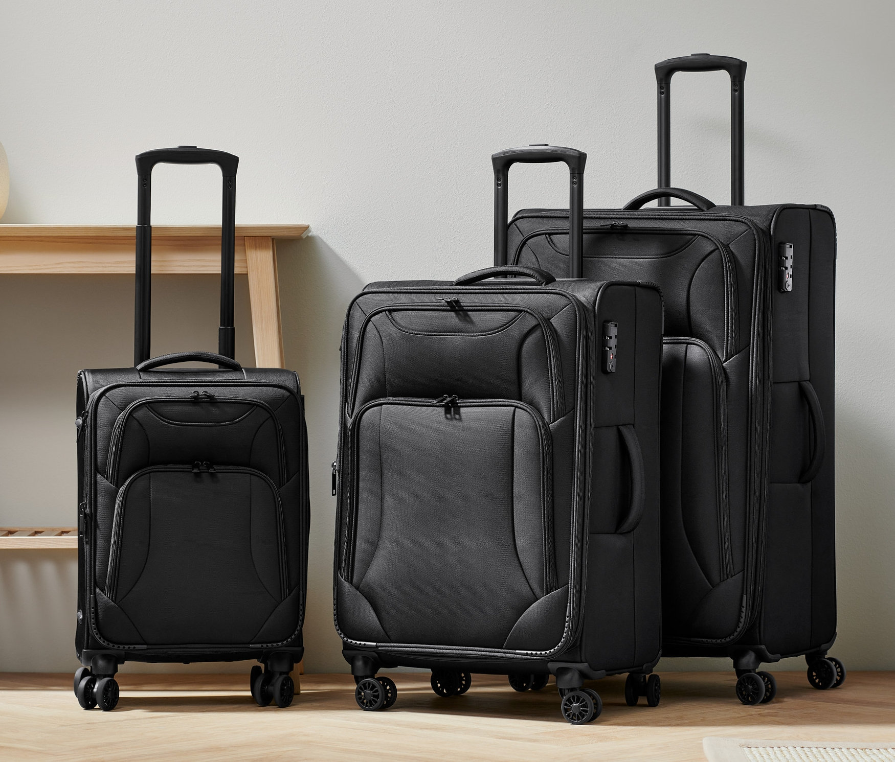 Tri textilné kufre v rôznych veľkostiach (malý, stredný a veľký) stoja vedľa seba.