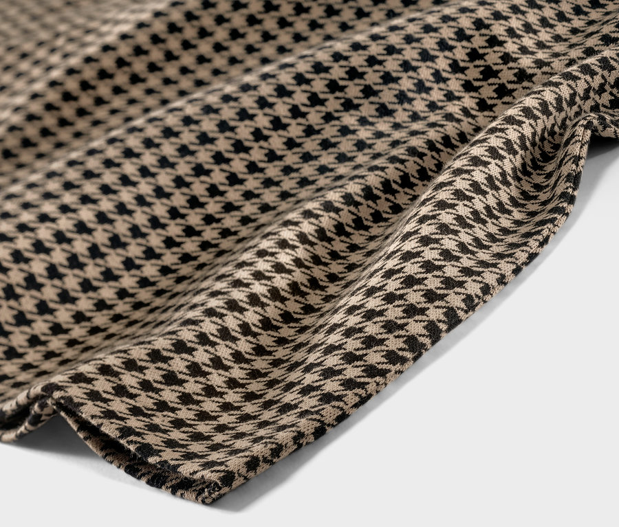 Detail látky sukne z teplákoviny so žakárovým vzorom kohútej stopy.