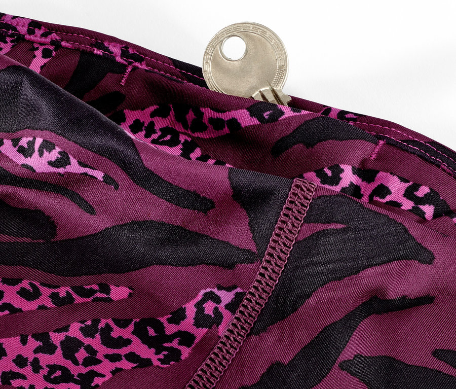 Detail fialových trojštvrťových športových legín s celoplošnou potlačou a kľúčom vo vrecku.