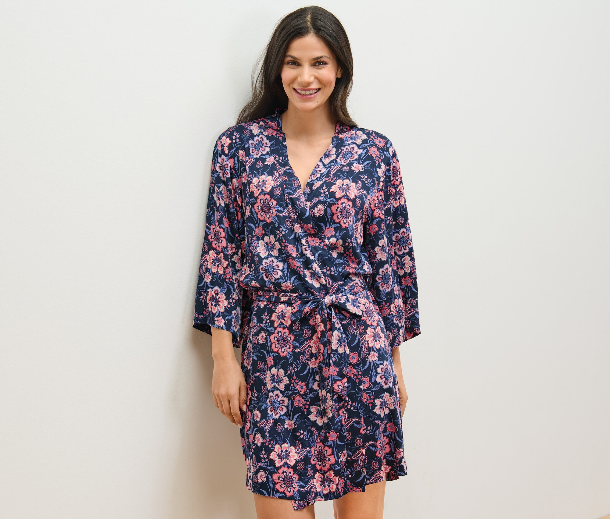 Žena má na sebe tkaný župan s kvetinovým vzorom.