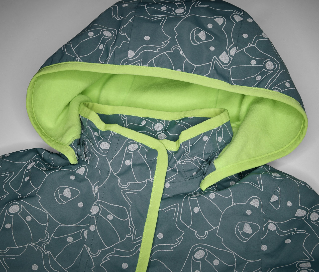 Detail detskej termo bundy do dažďa s reflexnými prvkami, s kapucňou a potlačou zvierat.