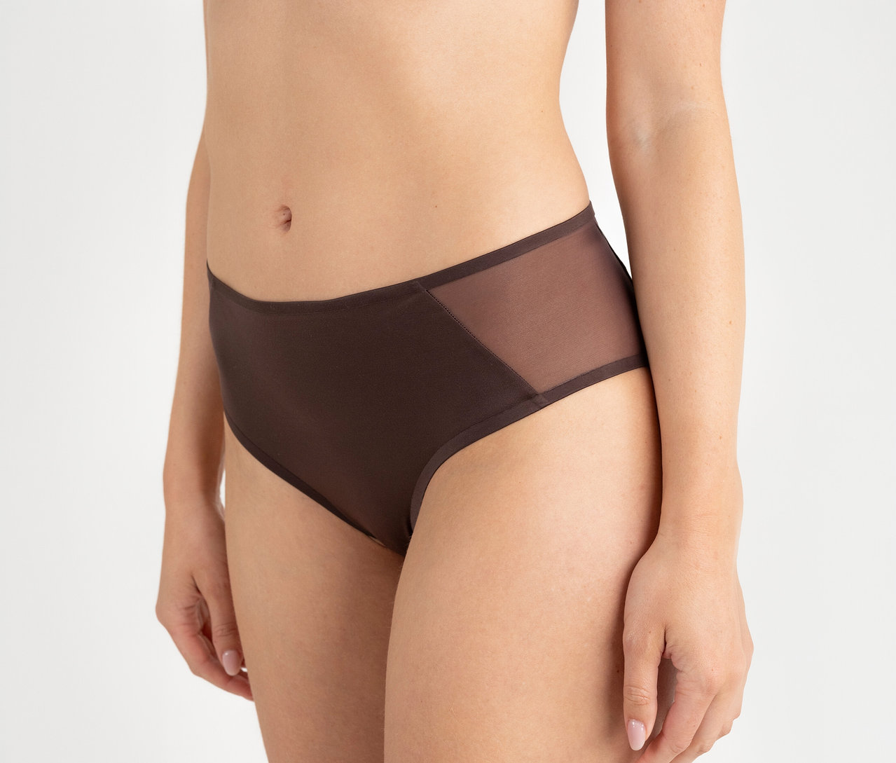Osoba má na sebe tmavohnedé nohavičky Passionata High Waist Slip „Bianca“ s bočnými sieťovanými panelmi.