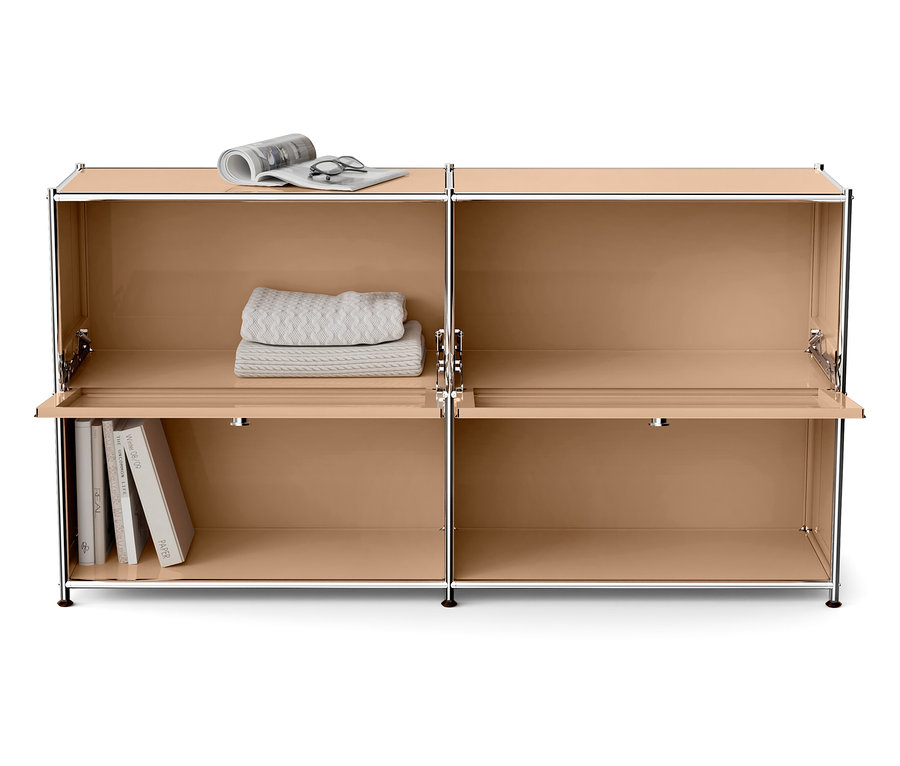 Béžová skrinka so štyrmi priehradkami, z ktorých dve majú otvorené dvierka. Hore je deka, noviny a okuliare a dole sú knihy.