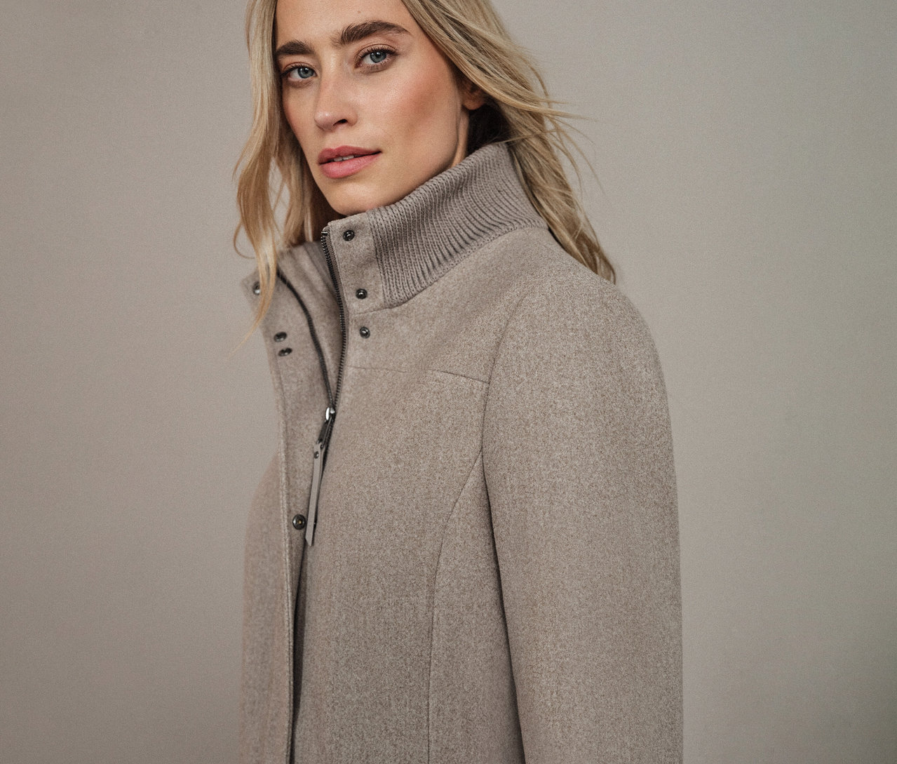 Žena má na sebe krátky kabát Street One.