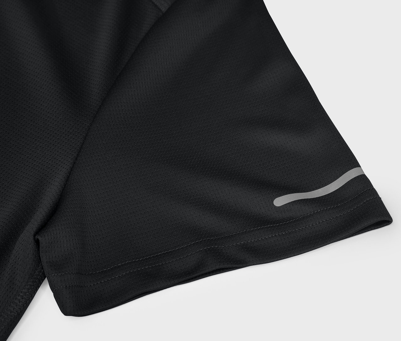 Detail čierneho športového trička s krátkym rukávom a reflexným prvkom.