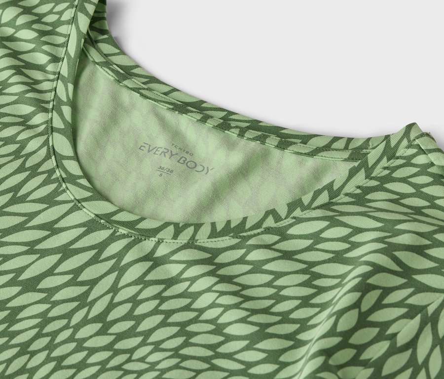 Detail zeleného trička s potlačou.