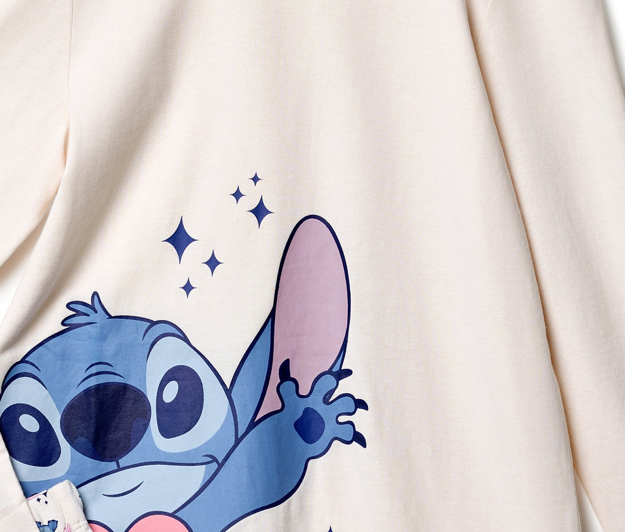Detailný pohľad na krémový top s modrou potlačou Stitcha a trblietavými hviezdami.