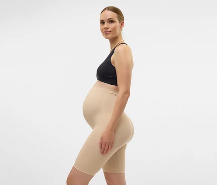 Tehotná žena v športovej podprsenke a telových skinny šortkách MAMALICIOUS »MLTIA JEANNE«, čierne, zboku na bielom pozadí.
