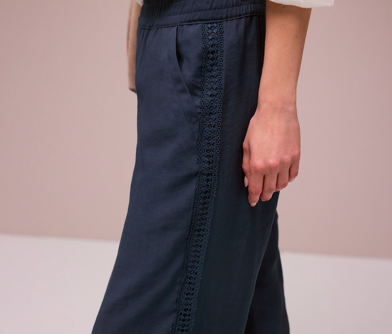 Žena má na sebe tmavomodré nohavice Street One »Emee« s ozdobnými prúžkami.