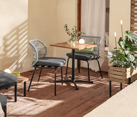 Zariadenie balkóna s variabilnou súpravou balkónového lounge nábytku Elin, stolíkom, stoličkami s textilným výpletom, 2 vankúšmi do exteriéru, kvetináčom a solárnymi zapichovacími svietidlami.