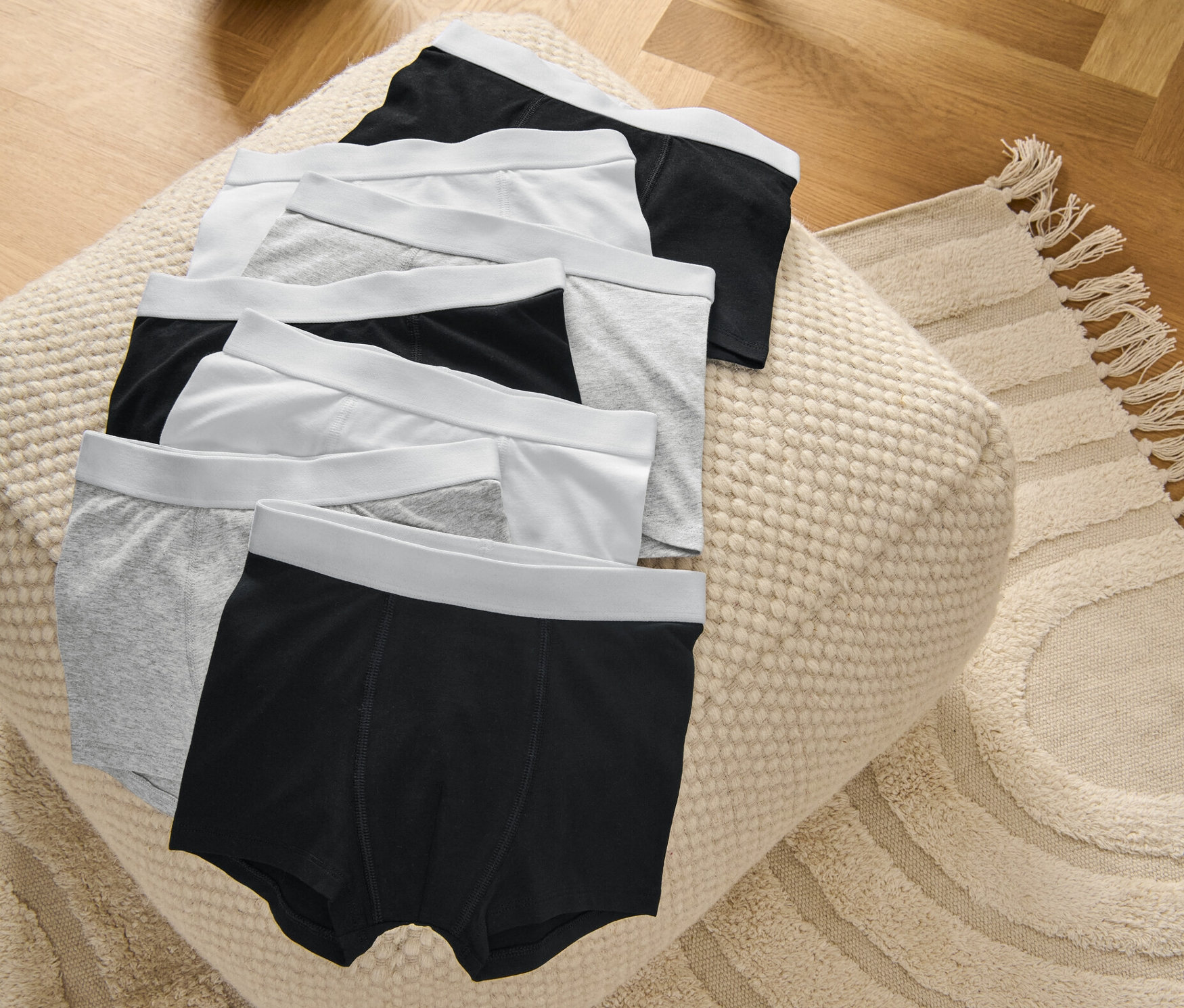 Na pufe ležia detské boxerky, 7 ks, sivé/biele/čierne.