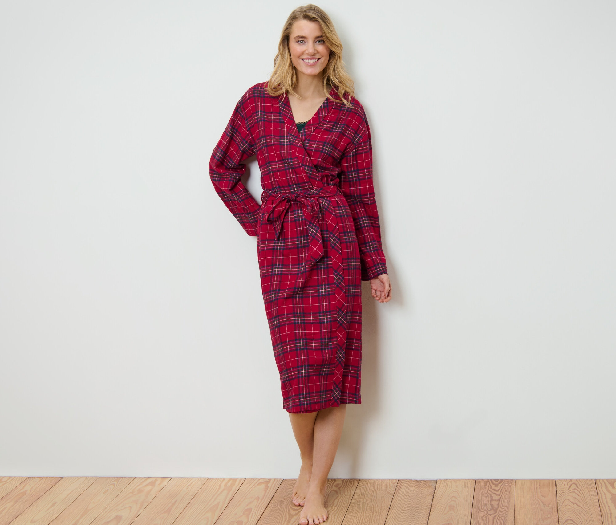 Blondína stojí a má na sebe červený kockovaný flanelový župan.