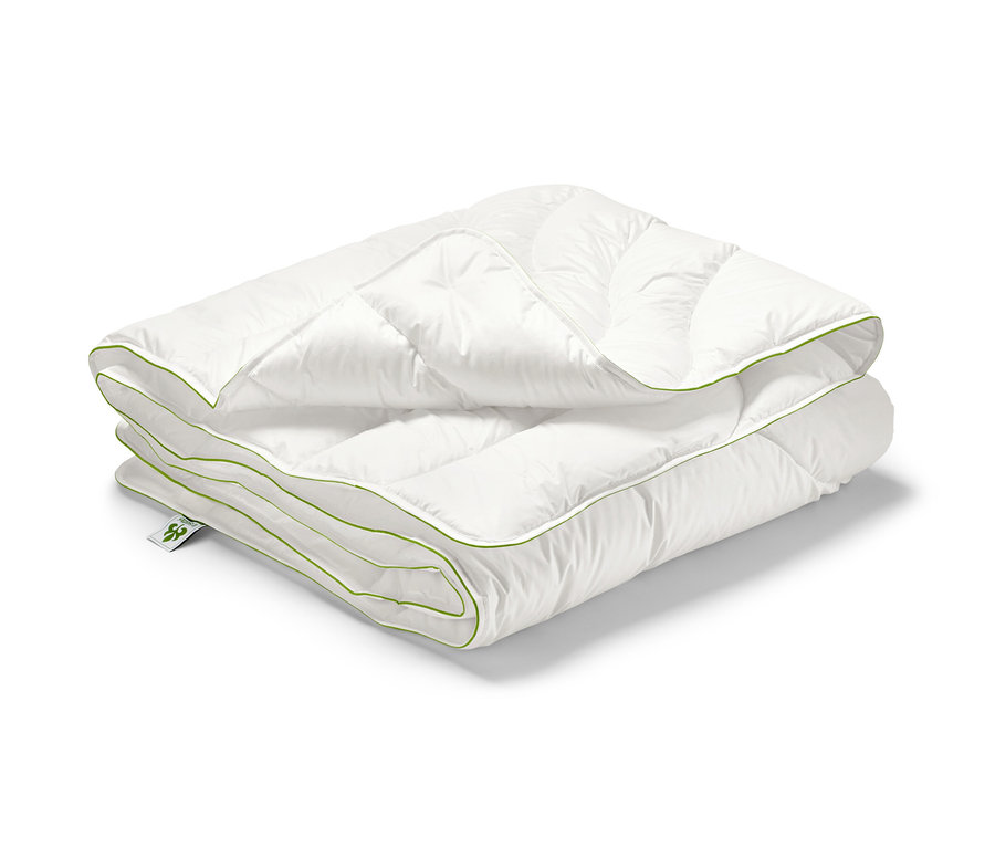 Poskladaná biela prešívaná prikrývka irisette® greenline Megafil® BIO so zeleným okrajom, štandardnej veľkosti.