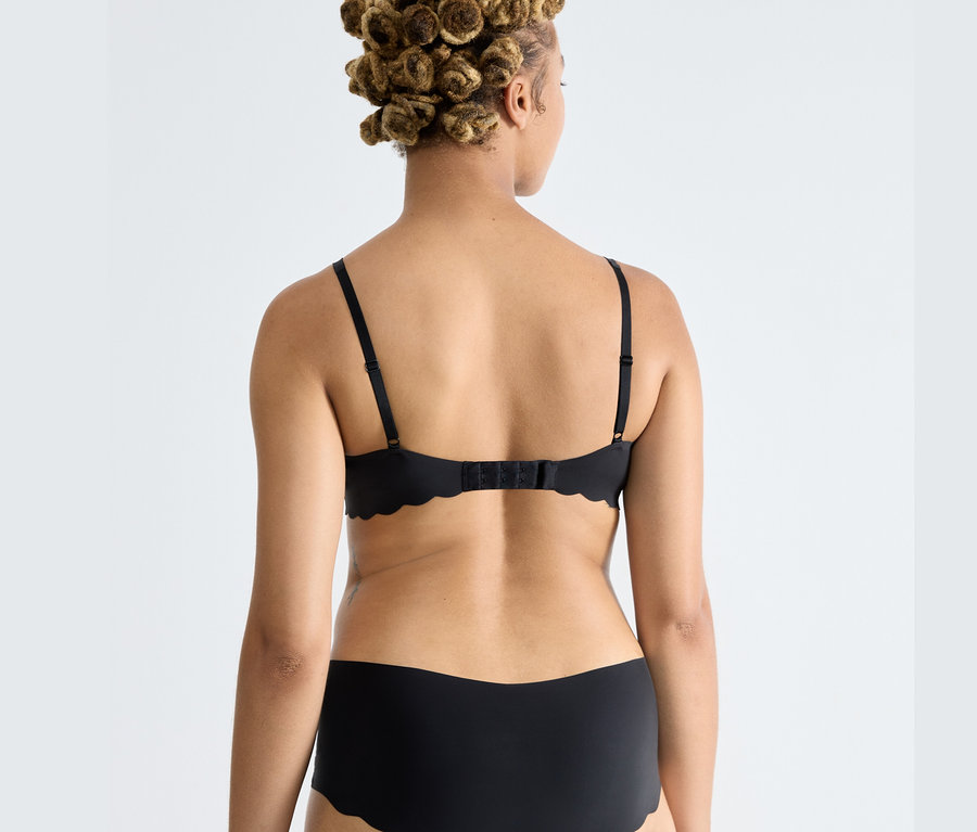 Zozadu je vidieť žena, ktorá má na sebe čiernu podprsenku sloggi ZERO Microfibre 2.0 Soft bra.