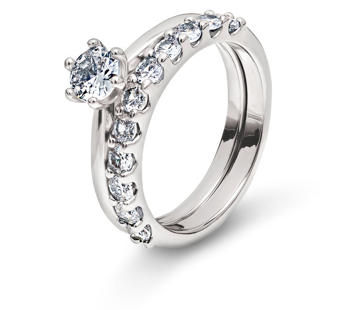 Dva strieborné prstene s čírymi kameňmi na bielom pozadí.