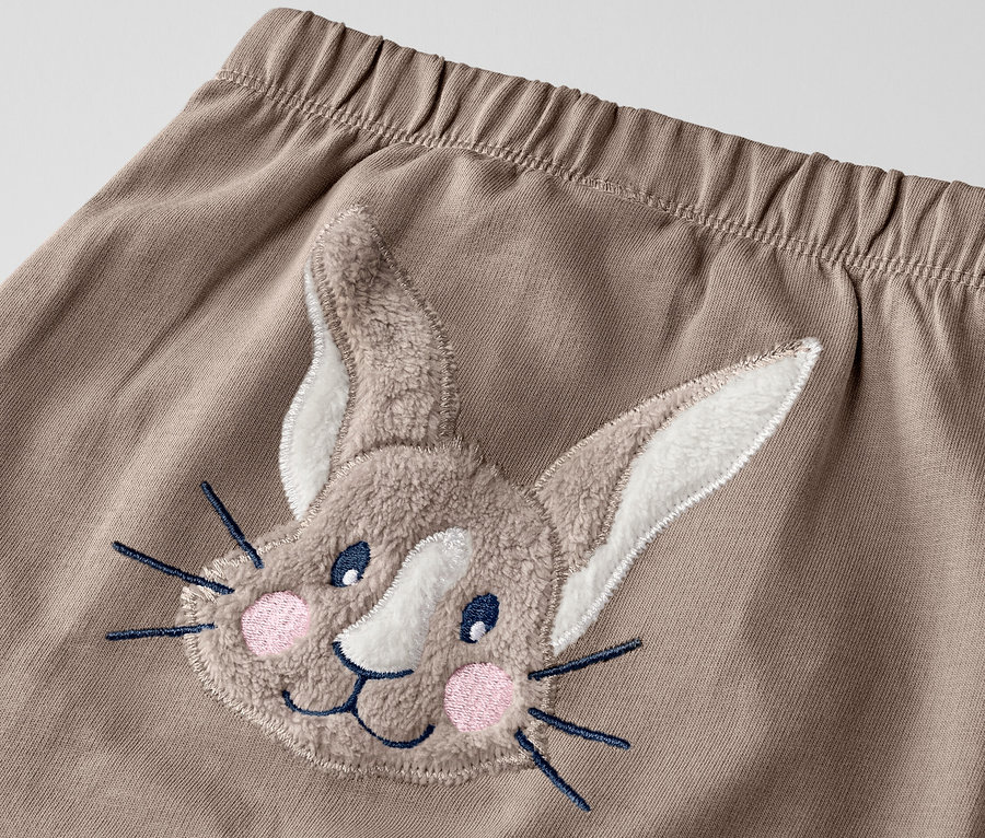Detail detských nohavíc s nášivkou zajaca.