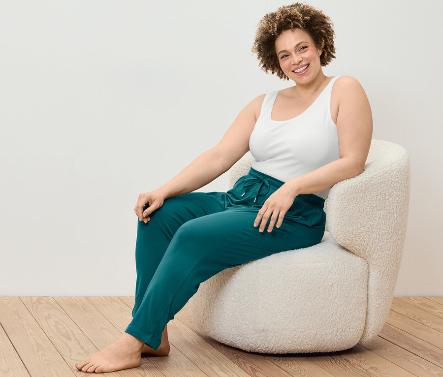 Žena sedí v kresle a má na sebe tielka, 2 ks a pyžamové nohavice.