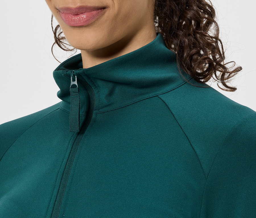Detail ženy v zelenej bunde na zips so stojačikom.