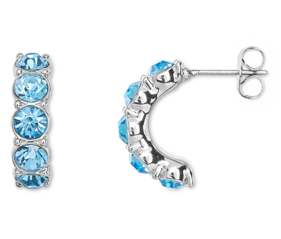 Detailná fotografia páru strieborných náušníc, každá s piatimi svetlomodrými kameňmi.