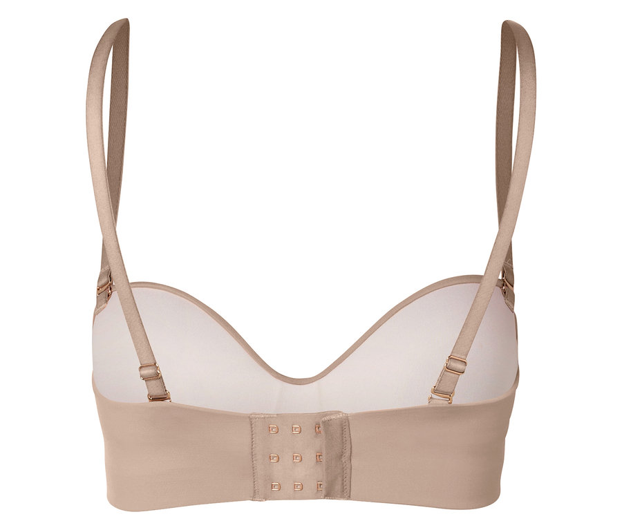 Detailný záber na zadnú časť béžovej podprsenky s nastaviteľnými ramienkami a háčikovým zapínaním.