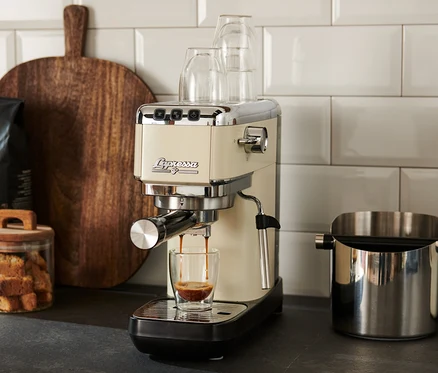 Krémový pákový kávovar »Lapressa« pripravuje espresso do sklenice.